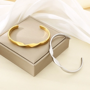 Elegant 18K gold and silver plated stainless steel wavy bangles for women on silk