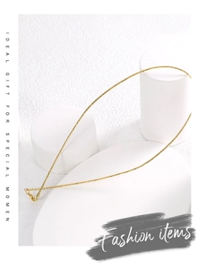Detailed close-up of a minimalist golden spring collar necklace on a geometric pedestal