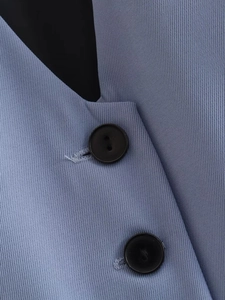 Gros plan sur le tissu en sergé bleu clair et les boutons en résine noire d'un gilet Y2K