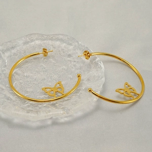 Minimalist golden stainless steel butterfly hoop earrings on a decorative glass tray