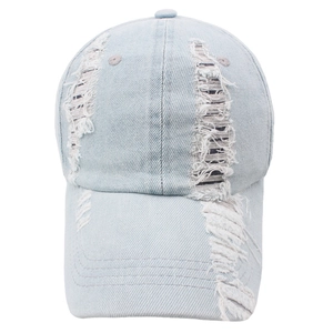 Close-up of distressed light blue denim baseball cap with frayed hole details