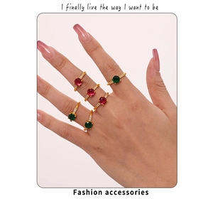 Detailed view of stacked gold plated rings with rose red and green cubic zirconia stones