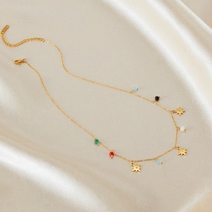 Detailed shot of golden star pendant necklace with multi-color beads on silk fabric
