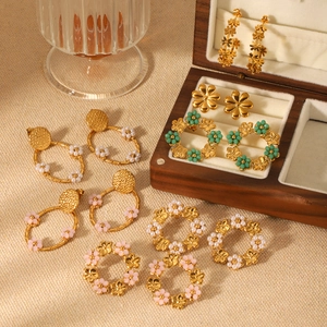 Parure de boucles d'oreilles fleurs en acier 18K et créoles en perles sur boîte en bois