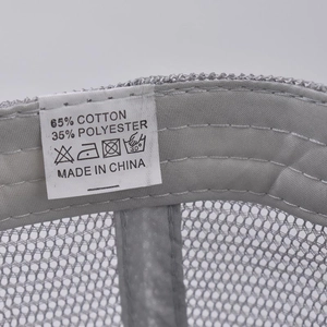 Detail view of the wash label on a gray ponytail cap showing 65% cotton material info