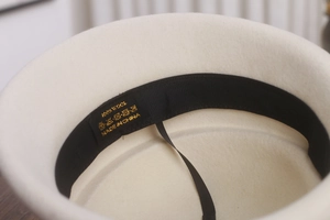 Détail de l'intérieur d'un béret 100% laine avec bandeau noir et étiquette d'entretien