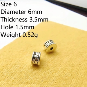 Macro detail of 6mm vintage Tibetan silver spacer beads with engraved pattern for DIY jewelry