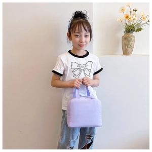 Detail of a purple insulated lunch tote bag held by a model for a compact casual look
