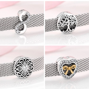 Macro detail of S925 sterling silver charms featuring tree of life and infinity symbols
