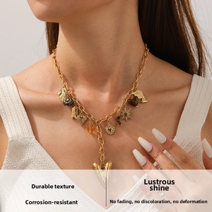 Detail of gold-plated stainless steel Y-necklace with heart and sun charm pendants