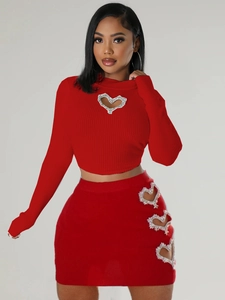 Red knit two-piece set featuring rhinestone heart cut-outs on crop top and mini skirt