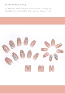 Flat lay of pink gradient press-on nails with blue floral accents and white pearls