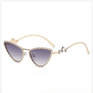 Detailed close-up of golden cat-eye sunglasses with pearl beads and star metal accents