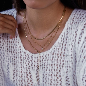 Detail of layered 18K gold plated stainless steel teardrop zircon blade chain necklace