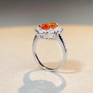 S925 sterling silver ring featuring an oval orange gemstone with a sparkling floral halo