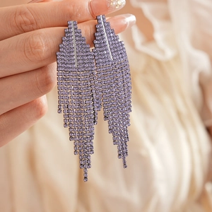 Macro shot of long purple rhinestone tassel earrings with a cascading tiered fringe design