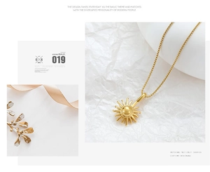 Detailed view of a gold sunburst pendant necklace on a refined textured background