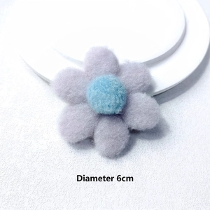 Detailed view of a 6cm lavender plush flower accessory with a blue core and soft texture