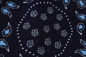 Macro detail of navy blue knit cardigan featuring intricate paisley jacquard patterns