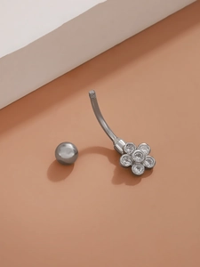 Detailed view of silver flower navel ring with inlaid zircon stones on geometry block