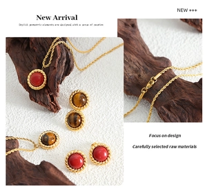 Detail of gold snake chain necklace and tiger eye stud earrings set on wood background