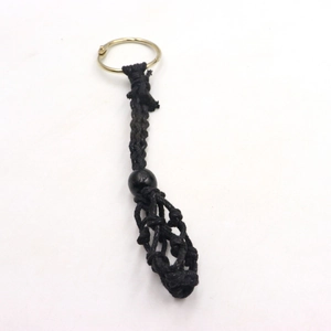 Detail of black handmade woven cord keychain with a wooden bead and gold metal ring