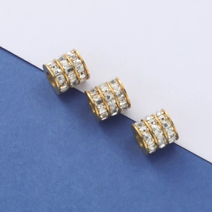 Macro view of gold plated cylindrical spacer beads with multi-layer crystal inlay details