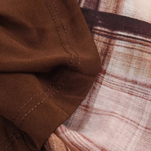Vista macro detallada de la tela de punto marrón con costuras finas y estampado de cuadros