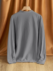 Detail view of the back of a men's loose linen shirt with mandarin collar in dark grey