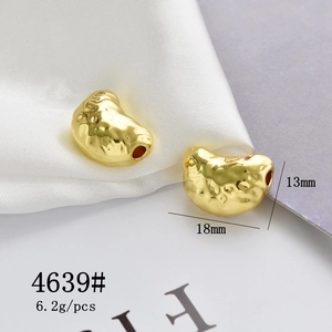 Macro shot of 18x13mm gold bean-shaped pendant with textured surface for DIY jewelry