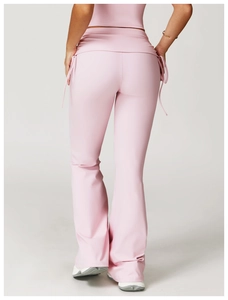 Detail view of pink flare yoga pants featuring adjustable side drawstrings and high waist