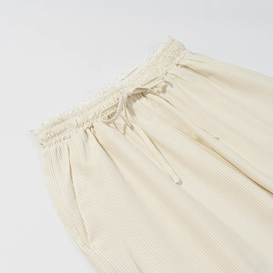 Détail de la taille élastique avec cordon et dentelle sur le pantalon rayé