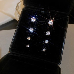 Close-up of 4 pairs of magnetic cubic zirconia stud earrings in various sizes on black velvet