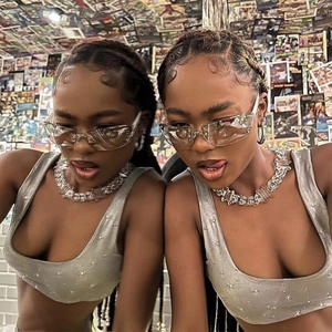 Close-up of rimless square diamond sunglasses with chunky metal chains in Y2K street style