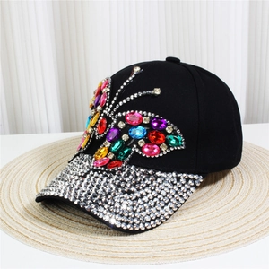 Close-up of a black denim baseball cap with rhinestone butterfly and studded brim