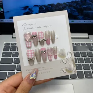 Detailed view of pink plaid press-on nails with silver glitter and 3D heart charms