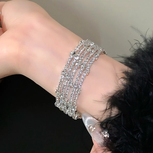 Macro-opname van een zilverkleurige vierlaagse strass armband om de pols van model
