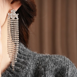 Primo piano di orecchini vintage a nappa con strass scintillanti indossati da una modella