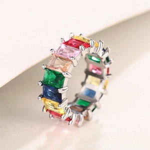 Macro-opname van zilveren regenboog eternity ring met kleurrijke smaragdgeslepen stenen