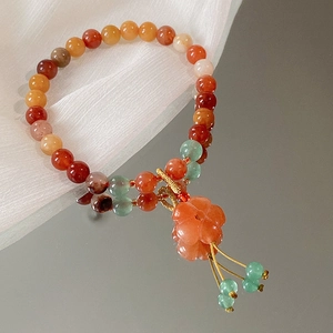 Nahaufnahme von buntem Perlenarmband mit Blumenanhänger und feinen Quasten im China-Stil