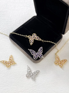 Macro shot of butterfly jewelry pendants with cubic zirconia inlay in gold and silver