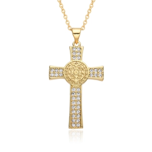 Macro shot of gold cross pendant featuring micro-set zircon and St. Benedict medal