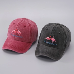 Close-up of pink flamingo embroidery on washed cotton baseball caps in burgundy and charcoal