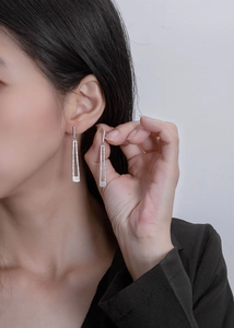 Detail of long rectangular silver tassel earrings with micro-pave crystals on model