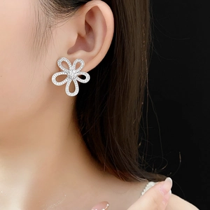 Gros plan de boucles d'oreilles fleurs évidées en argent avec zircons sur un mannequin