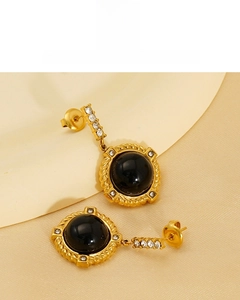 Détail de boucles d'oreilles vintage dorées 18K avec pierre noire et cristaux brillants
