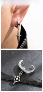 Macro detail of silver stainless steel cross pendant earrings with white zircon stone