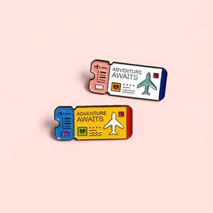 Creative airplane ticket enamel pins with Adventure Awaits text on pink background