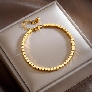 Golden square beaded bracelet on jewelry box with chain extension and lobster clasp