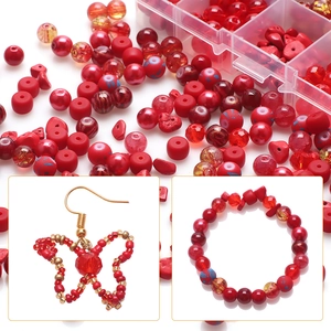 Macro view of red glass beads and stones in a plastic box for DIY jewelry making
